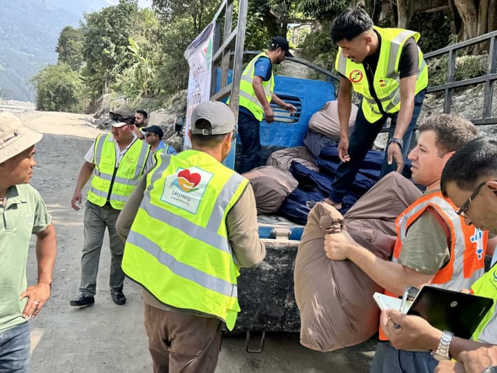 Volunteers unload the tent bundles from the truck