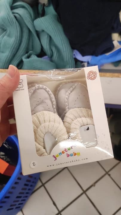 A pair of leather baby booties in their box
