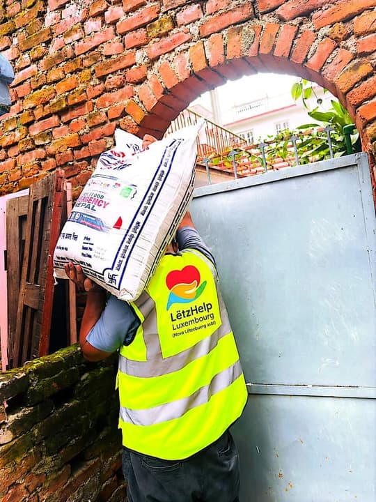 A volunteer carrying a relief sack on his shoulder